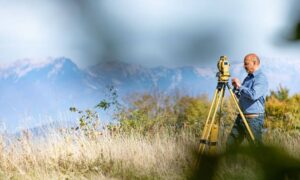 Alta land title survey boundary verification - ALTA SURVEY Utah Land surveyor using a total station to verify a property corner for an ALTA Land Title Survey in open terrain