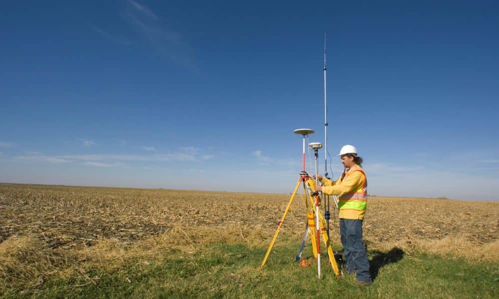 Land surveyor using GPS equipment during topographic surveys in open terrain