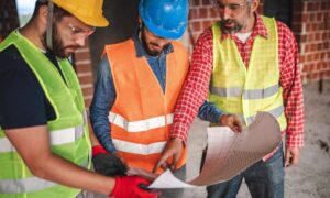 Construction team reviewing plans during a construction survey check