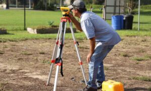 Land survey before buying a new home with a surveyor measuring a residential property
