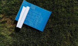 Construction blueprint laid out on grass to illustrate project plans and as-built documentation