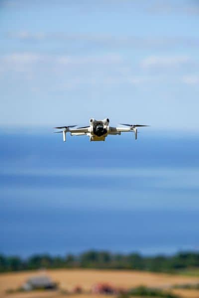 Survey drone flying over land during a drone surveying mission to collect LiDAR data for mapping and construction planning
