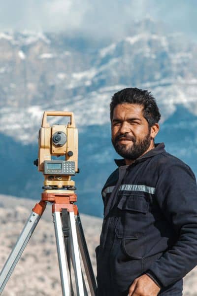 Elevation survey land surveyor tools - ALTA SURVEY Utah Licensed land surveyor using total station equipment to perform an elevation survey in mountainous terrain