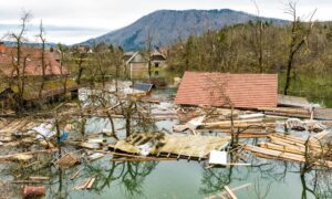 Flooded homes and debris near mountains after burn-scar flooding showing the importance of a flood elevation survey