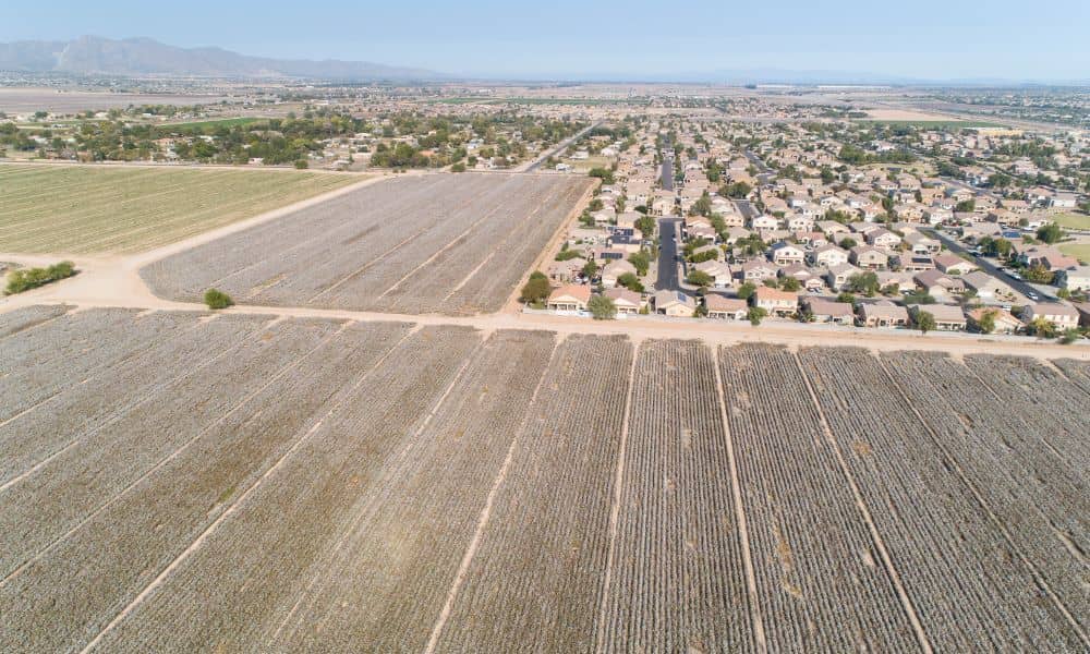 Aerial view of farmland being converted into a new housing subdivision, showing how rapid development increases the need for a subdivision survey