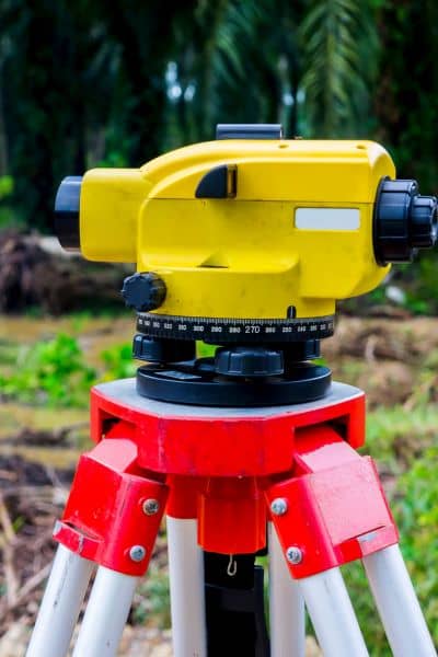 Surveying equipment set up on a tripod to measure land and mark boundaries during a subdivision survey