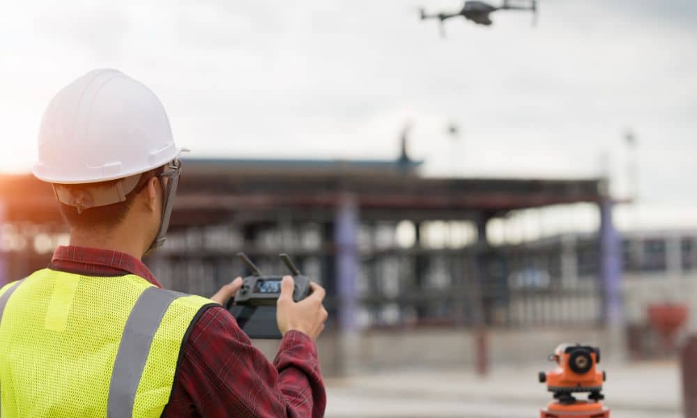 Licensed land surveyor using drone land surveying technology at an active construction site