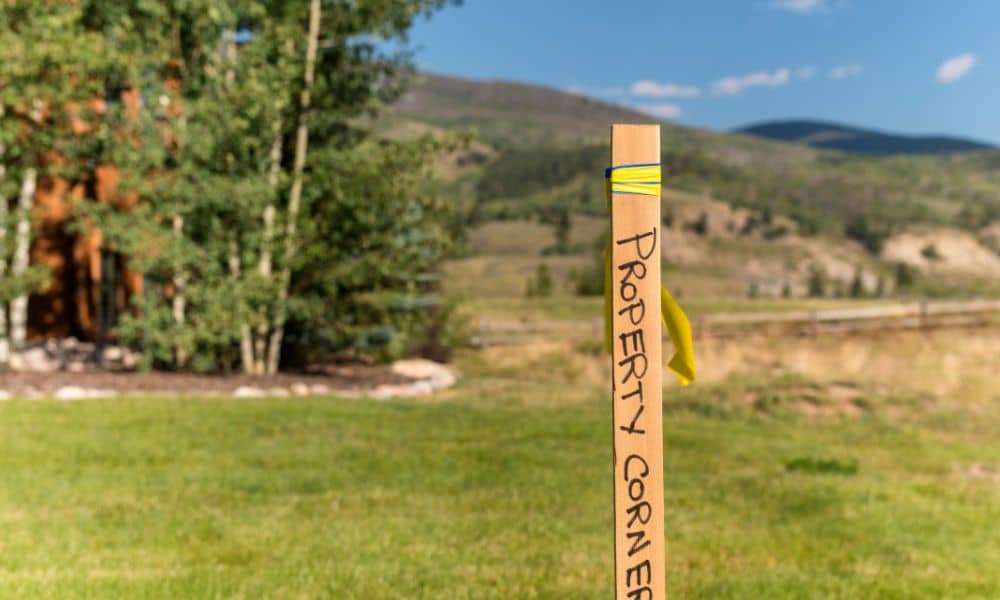 Wooden property corner stake in yard - ALTA SURVEY Utah Property survey marker showing the true corner of a residential lot