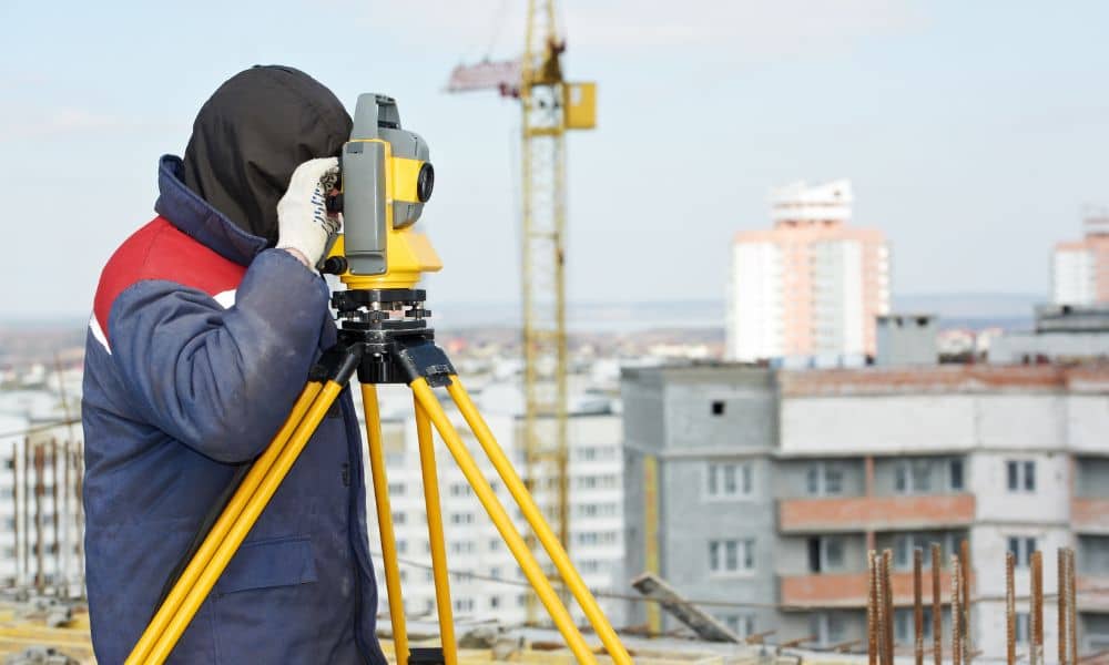Land surveyor measuring a development site before construction planning begins