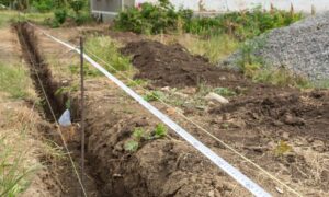 House staking layout with string lines marking foundation corners before concrete pour