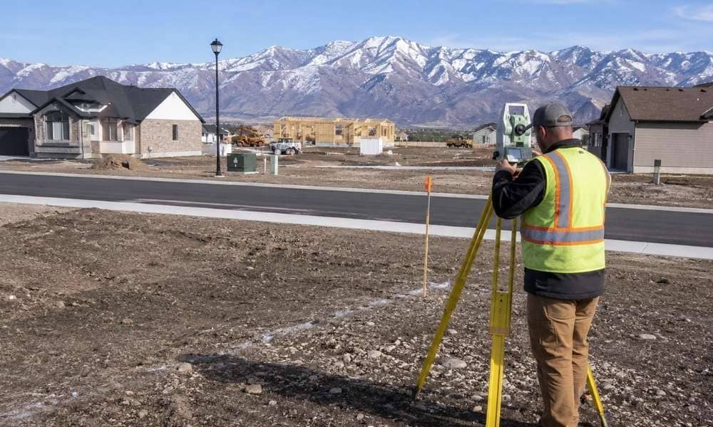 Land surveyor near me checking a residential lot before new home construction in Utah